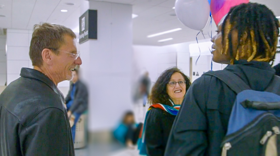 Galen Workman and Melanie Nathan greet Junior Mayema at SFO as he arrives from South Africa.